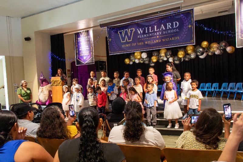 Families watching students on stage beneath the new banners
