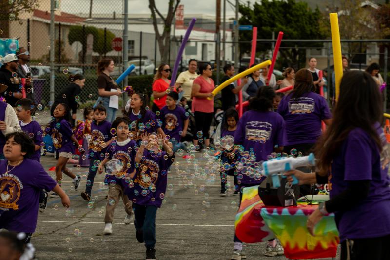 Students running past the purple bubble arch