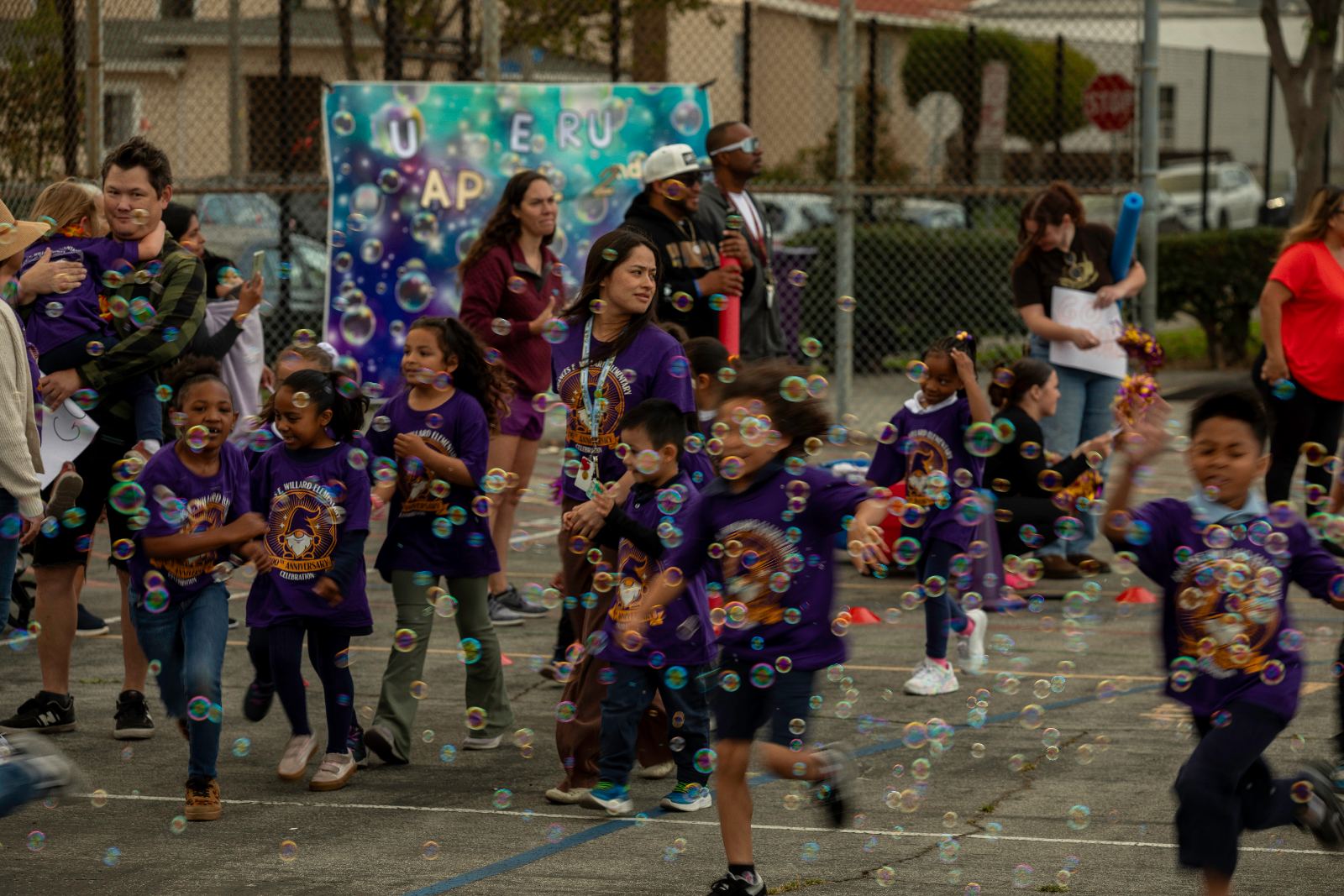 Students and families running through bubbles at a Willard school event