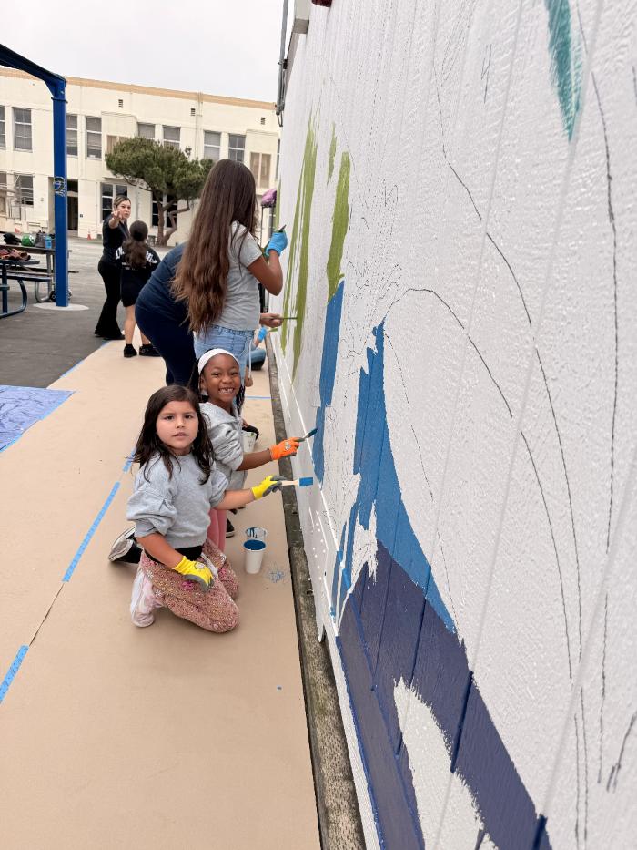 Families painting the mural together