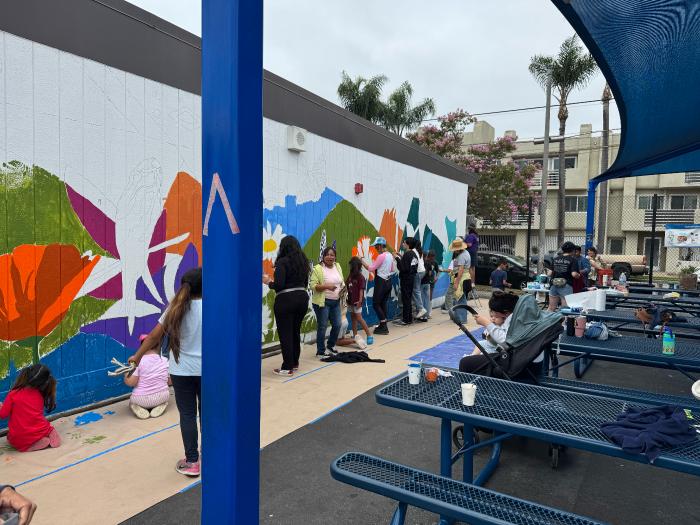 Volunteers painting mural flowers together